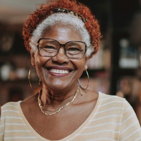 a woman wearing glasses and smiling